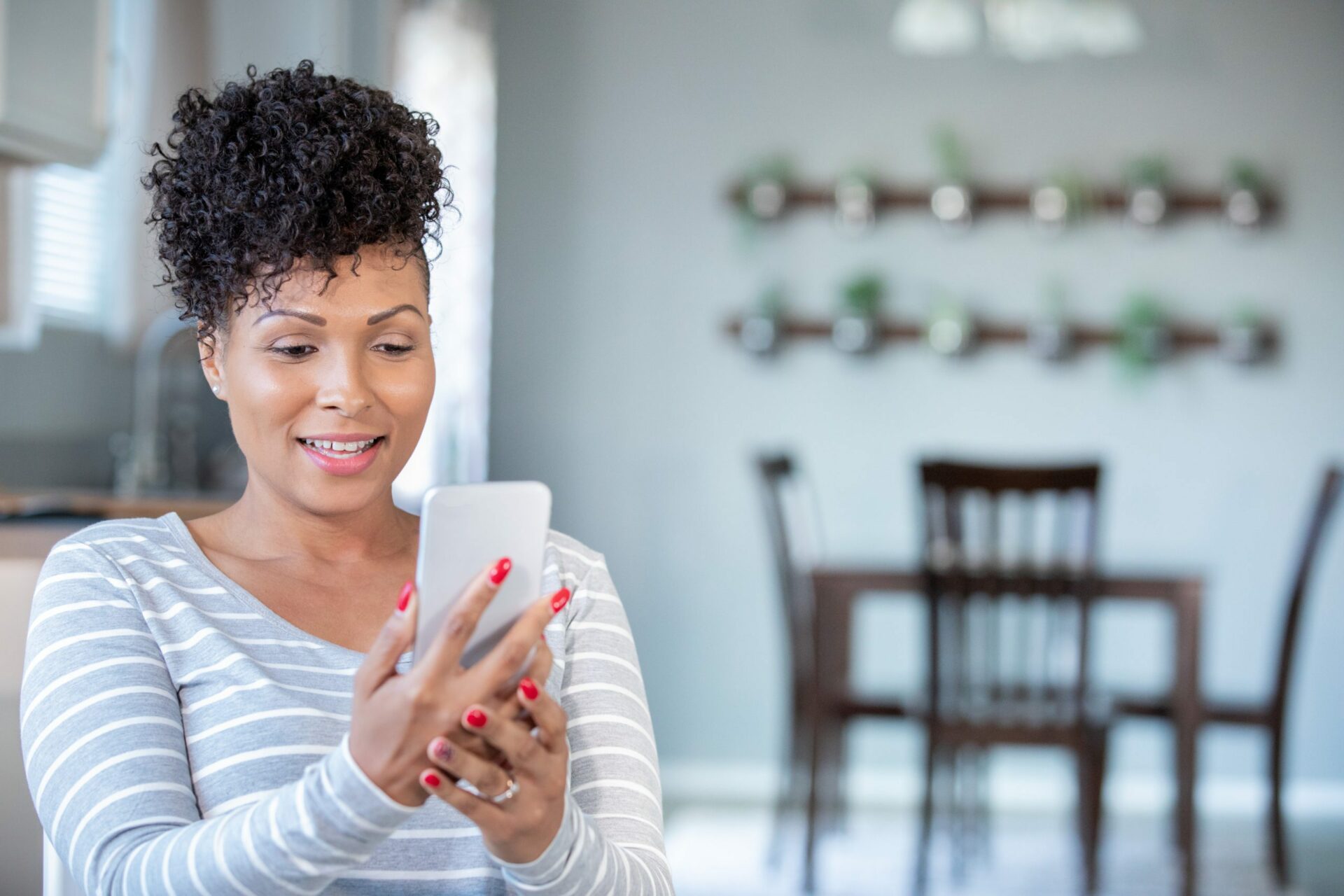 Beautiful mature woman uses smart phone for telemedicine appointment with doctor