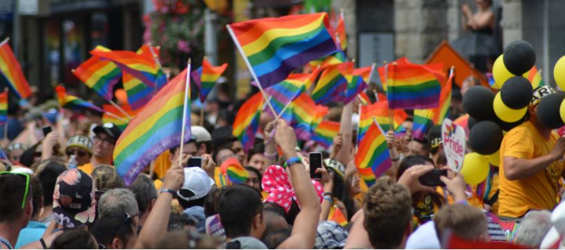 Image of group waving rainbow pride flags